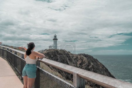 Photo for A woman looking at the white lighthouse at the coast of Byron Bay - Royalty Free Image
