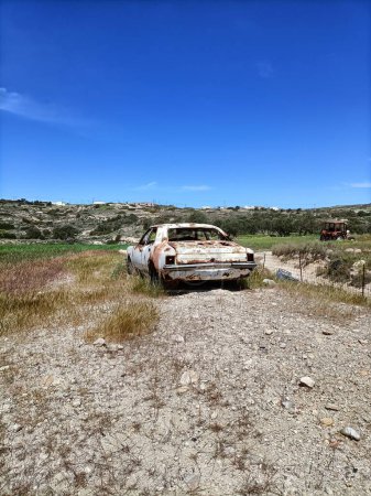 Foto de Un disparo vertical de un viejo coche blanco oxidado abandonado en medio de un campo - Imagen libre de derechos