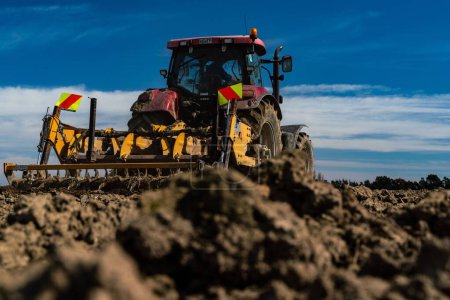 Téléchargez les photos : Tracteur labourant les champs dans un bon sol - en image libre de droit
