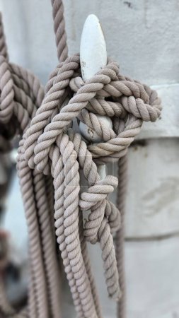 Foto de Un plano vertical de los detalles de la cuerda de la vela en el mástil de un velero. Equipo marino, nudo de mar, viaje - Imagen libre de derechos