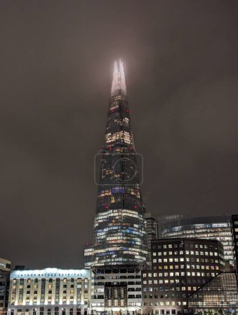 Foto de Un plano vertical del edificio Shard durante una noche de niebla en Londres, Reino Unido. - Imagen libre de derechos