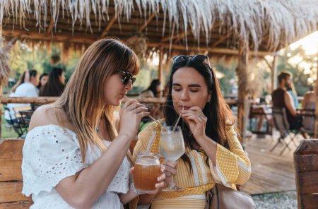Téléchargez les photos : Une prise de vue sélective de deux amis buvant des cocktails en vacances - en image libre de droit