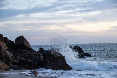 Téléchargez les photos : Un coucher de soleil pittoresque sur l'océan et le littoral rocheux - en image libre de droit