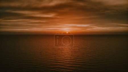 Foto de Una fascinante puesta de sol naranja sobre el horizonte del mar - Imagen libre de derechos
