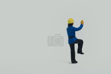 Photo for A miniature figure of a fireman standing on one leg on a white background - Royalty Free Image