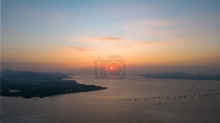 Téléchargez les photos : Une scène envoûtante de coucher de soleil au bord de la mer, parfaite pour le fond - en image libre de droit