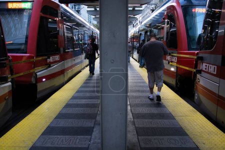 Foto de Los trenes rojos del metro que pasan en dos carriles y la gente que camina en la plataforma en el Houston, EE.UU. - Imagen libre de derechos