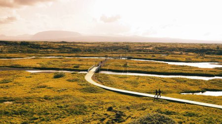 Téléchargez les photos : La vue aérienne des personnes marchant le long du sentier de la vallée du rift Islande - en image libre de droit