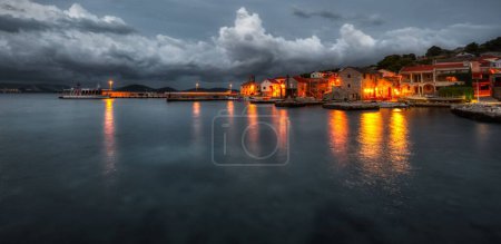Photo for A panoramic shot of illuminated beach houses on a cloudy evening - Royalty Free Image