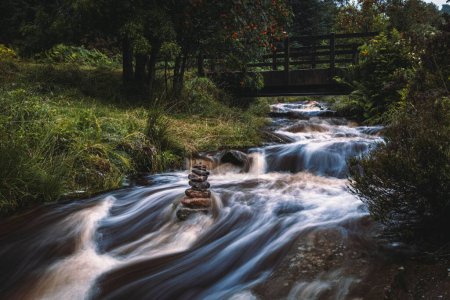 Foto de Una hermosa larga exposición del río que fluye rápido contra unas piedras bien equilibradas - Imagen libre de derechos