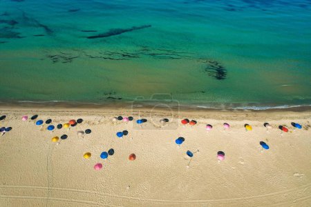 Foto de Una vista aérea de sombrillas de colores en una playa contra un mar azul en un día soleado de verano - Imagen libre de derechos