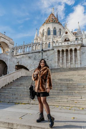Téléchargez les photos : Une jeune femme debout devant le château bastion du pêcheur à Budapest, Hongrie, plan vertical - en image libre de droit
