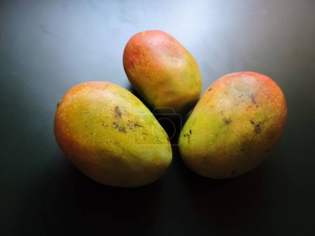 Téléchargez les photos : La mangue Gulab Khaas est un fruit délicieux qui présente un goût et une saveur rosés. Il a une peau rose rougissante ou rouge. Disponible en mai et juin. - en image libre de droit