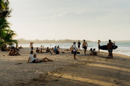 Foto de Un grupo de personas descansando en la playa con un mar al fondo - Imagen libre de derechos