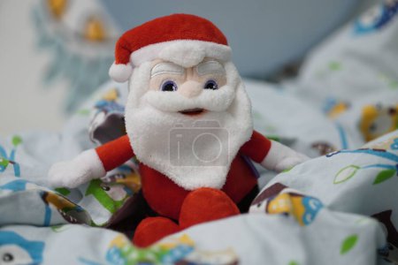 Foto de Un juguete de peluche de la marca Milka Santa Claus sentado en una sábana. - Imagen libre de derechos