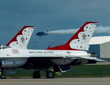 Photo for The small jets flying past parked thunderbirds at an airshow - Royalty Free Image