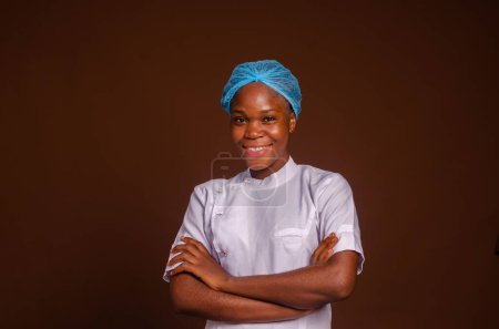 Foto de Un retrato de cerca de un joven médico feliz en el hospital sobre un fondo marrón - Imagen libre de derechos