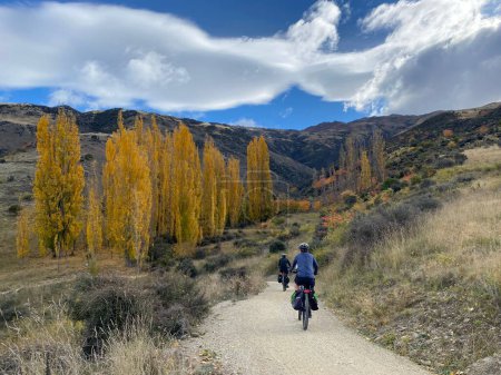 Téléchargez les photos : Deux cyclistes sur la piste cyclable Dunstan par une belle journée d'automne - en image libre de droit
