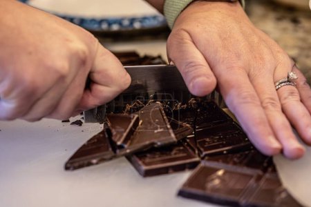 Téléchargez les photos : Un gros plan d'une barre de chocolat coupée à la main en morceaux - en image libre de droit