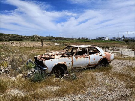 Foto de Un primer plano de un viejo coche blanco oxidado abandonado en medio de un campo - Imagen libre de derechos