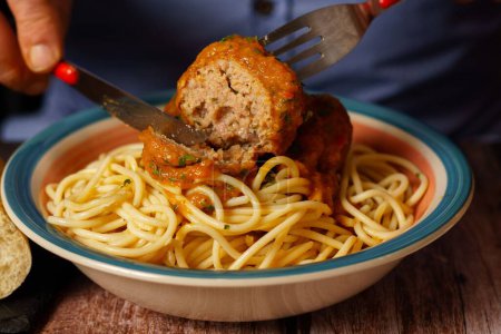 Photo for Close-up of a man eating a plate of meatballs with spaghetti - Royalty Free Image