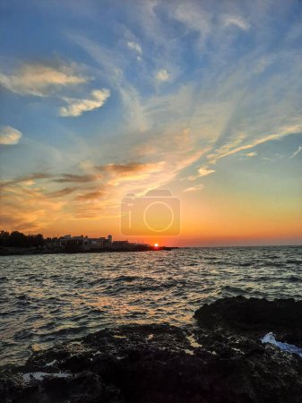 Colorful sunset over wavy blue dark sea, orange and blue sky, escape from city life, nature