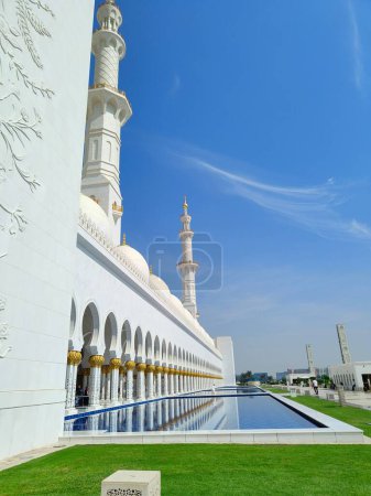 Photo for A vertical of the mesmerizing white walls of the Grand Mosque near fountains in Abu Dhabi - Royalty Free Image