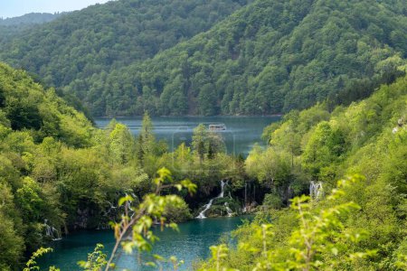 Foto de Un hermoso paisaje de un lago y vegetación con montaña en el fondo en el Parque Nacional de los Lagos de Plitvice - Imagen libre de derechos