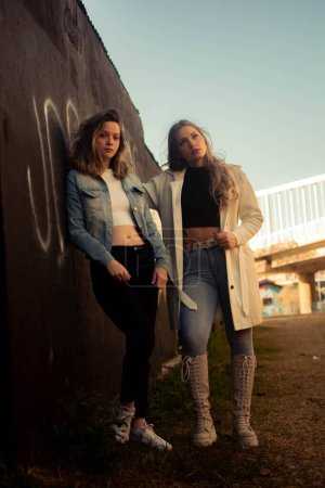 Photo for A vertical shot of a pair of young stylish female friends posing outdoors - Royalty Free Image