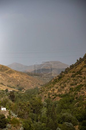 Photo for A vertical high angle shot of mountains covered with greenery on a cloudy day - Royalty Free Image
