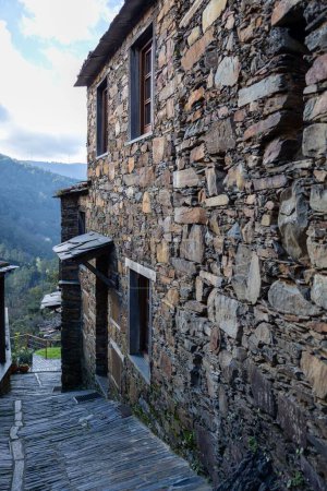 Téléchargez les photos : Plan vertical d'une ancienne ruelle en pierre schiste entourée de maisons moussues dans un village au Portugal - en image libre de droit