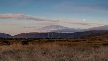 Téléchargez les photos : Une vue à couper le souffle d'un lever de soleil sur le champ dans l'ouest de l'Islande, avec un stratovolcan recouvert de glaciers Snaefellsnes en arrière-plan - en image libre de droit