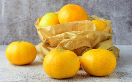 Foto de Un grupo de mandarinas en bolsa de papel kraft, natural y completa con vitamina a - Imagen libre de derechos