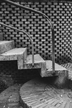 Téléchargez les photos : Un niveau de gris de vieux escaliers en pierre grunge avec clôture métallique et motif de mur de briques, plan vertical - en image libre de droit