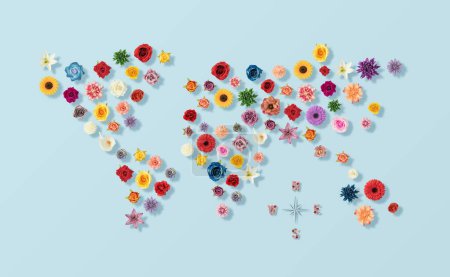 Photo for The layout of the world map with various colorful spring flowers on the blue background - Royalty Free Image