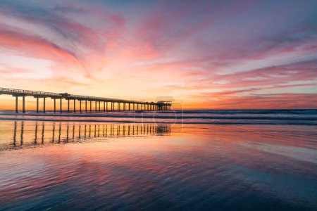 Téléchargez les photos : Un plan magique d'un coucher de soleil sur une jetée sur la côte de San Diego, colorant les environs - en image libre de droit