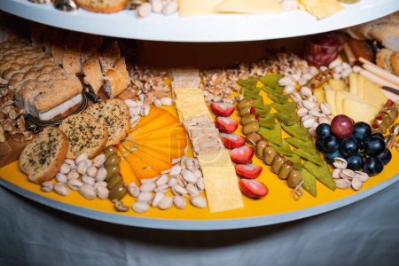 Photo for A selective closeup focus of a charcuterie board with crackers, nuts, and fruits - Royalty Free Image