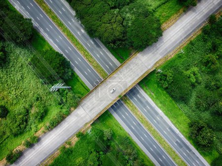 Photo for An aerial view of ETON City Overpass Bridge with single car passing by and lush green vegetation - Royalty Free Image