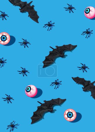 Téléchargez les photos : Un rendu 3D d'un concept d'horreur Halloween avec des araignées, des chauves-souris et des globes oculaires sur fond bleu - en image libre de droit