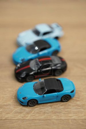 Foto de Un plano vertical de los pequeños modelos de automóviles Porsche de la marca Majorette sobre una superficie de madera - Imagen libre de derechos