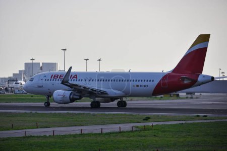Foto de Vista lateral del avión de Iberia al atardecer en el Aeropuerto de Humberto Delgado - Imagen libre de derechos