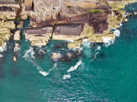 Téléchargez les photos : Une vue aérienne des falaises verdoyantes face à la mer le matin - en image libre de droit