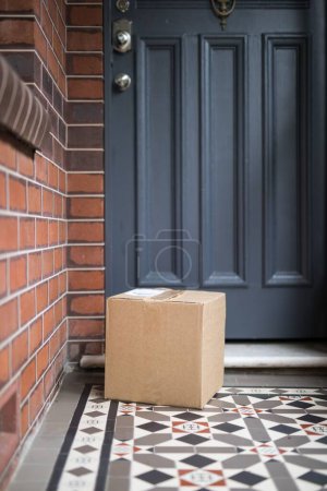 Photo for A vertical shot of a delivered package on the doormat - Royalty Free Image