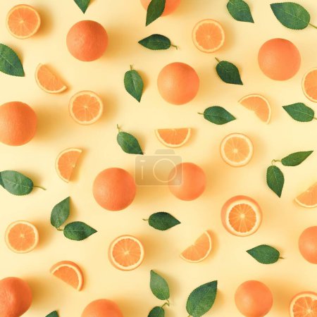 Téléchargez les photos : Un motif d'oranges et de feuilles vertes sur fond jaune - en image libre de droit