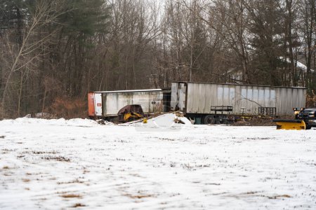 Téléchargez les photos : Une remorque abandonnée dans la neige avec des arbres d'hiver en arrière-plan, Amherst, États-Unis - en image libre de droit