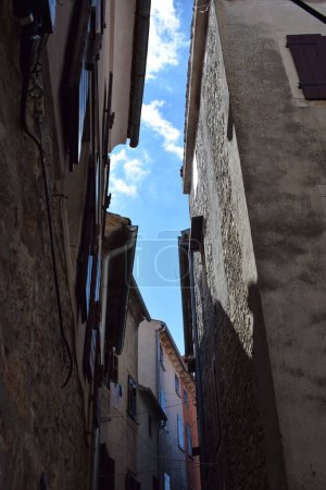 Photo for A low angle of old stone houses in narrow alley under blue sky - Royalty Free Image
