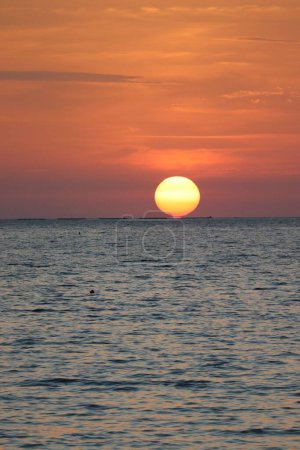 Téléchargez les photos : Un coup vertical du soleil se couchant sur l'océan - en image libre de droit