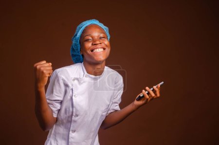Foto de Un hermoso retrato de una emocionada y alegre enfermera afroamericana sobre un fondo marrón - Imagen libre de derechos