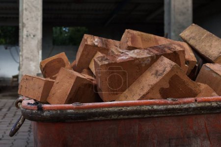 Téléchargez les photos : Un conteneur plein de briques rouges sur un chantier de construction - en image libre de droit