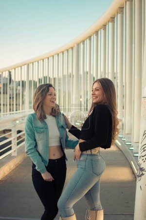 Photo for Two Hispanic girls dressed in casual clothes, smiling and posing outdoors on a sunny day, the concept of fashion - Royalty Free Image